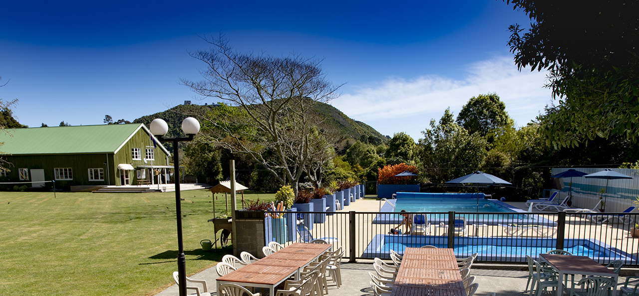 View of the grounds, including heated pool, lawn, trees, and clubhouse.